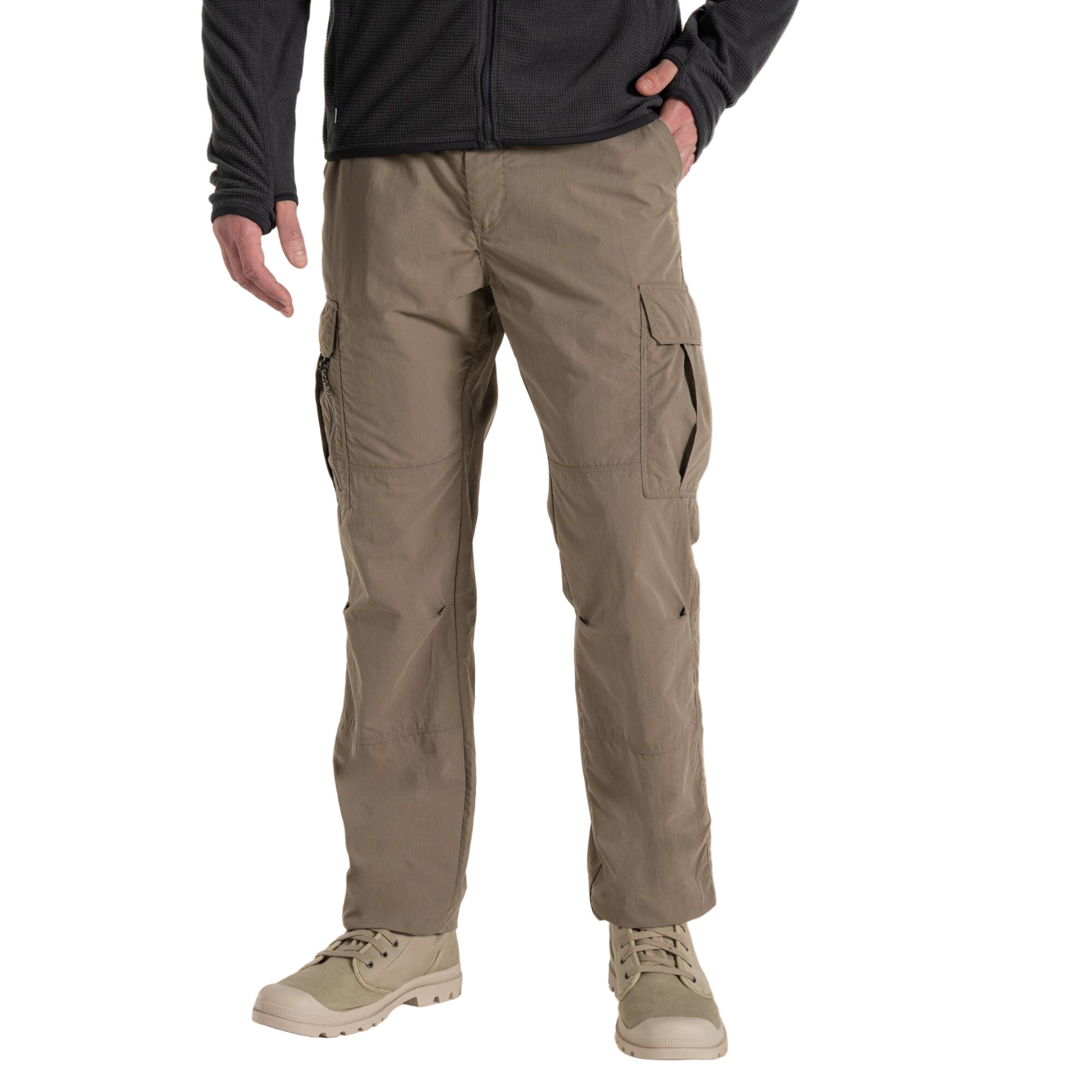 Person wearing beige cargo pants on a beige background