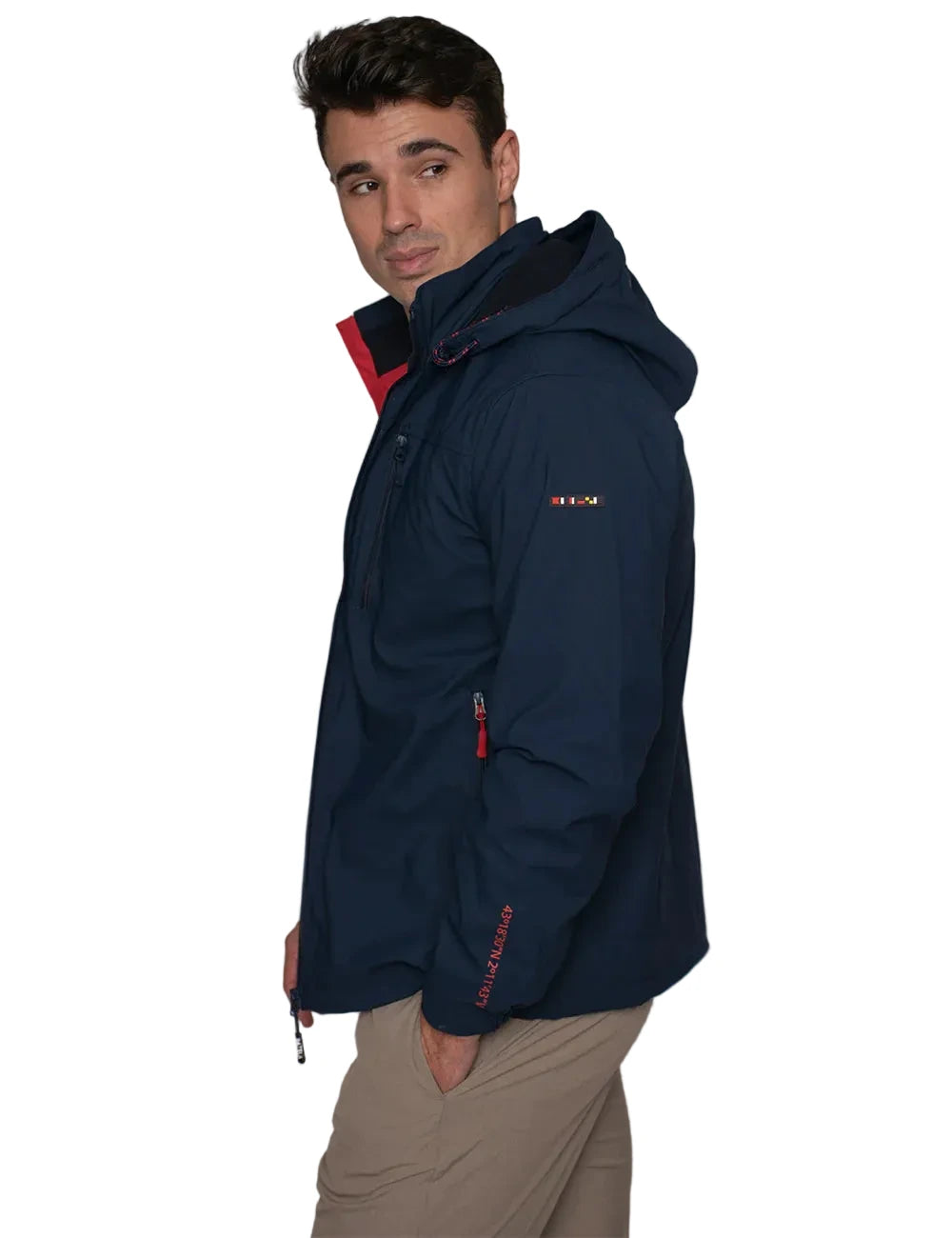 Man wearing a navy blue jacket with red accents against a plain background