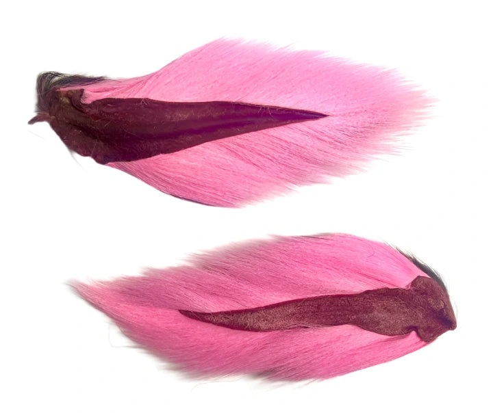 Two pink Midwest Premium Bucktails with dark roots, lying flat on a white background.